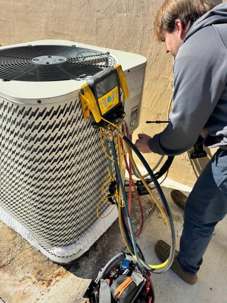 Technician performing AC maintenance