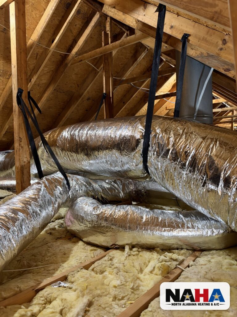 New insulated flex ducts hung with support straps in an attic