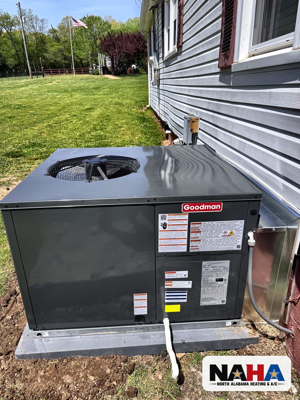 New packaged HVAC unit set on a pad beside a home
