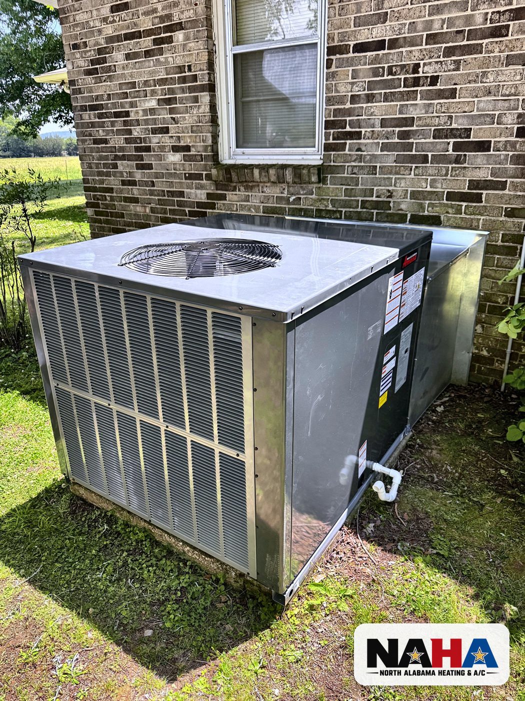 Packaged HVAC unit beside a brick home